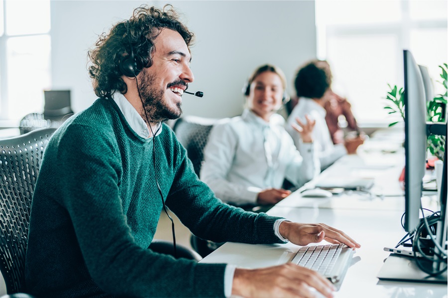 DOM Netherlands customer support team working in an open office, agents wearing headsets at their desks.
