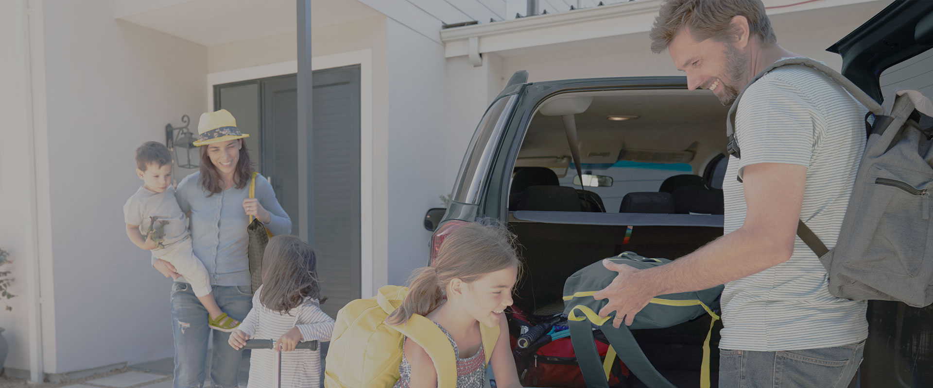 family putting their luggages inside the back of the car