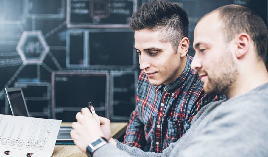 two man sitting down, one man holding easyflex transponder