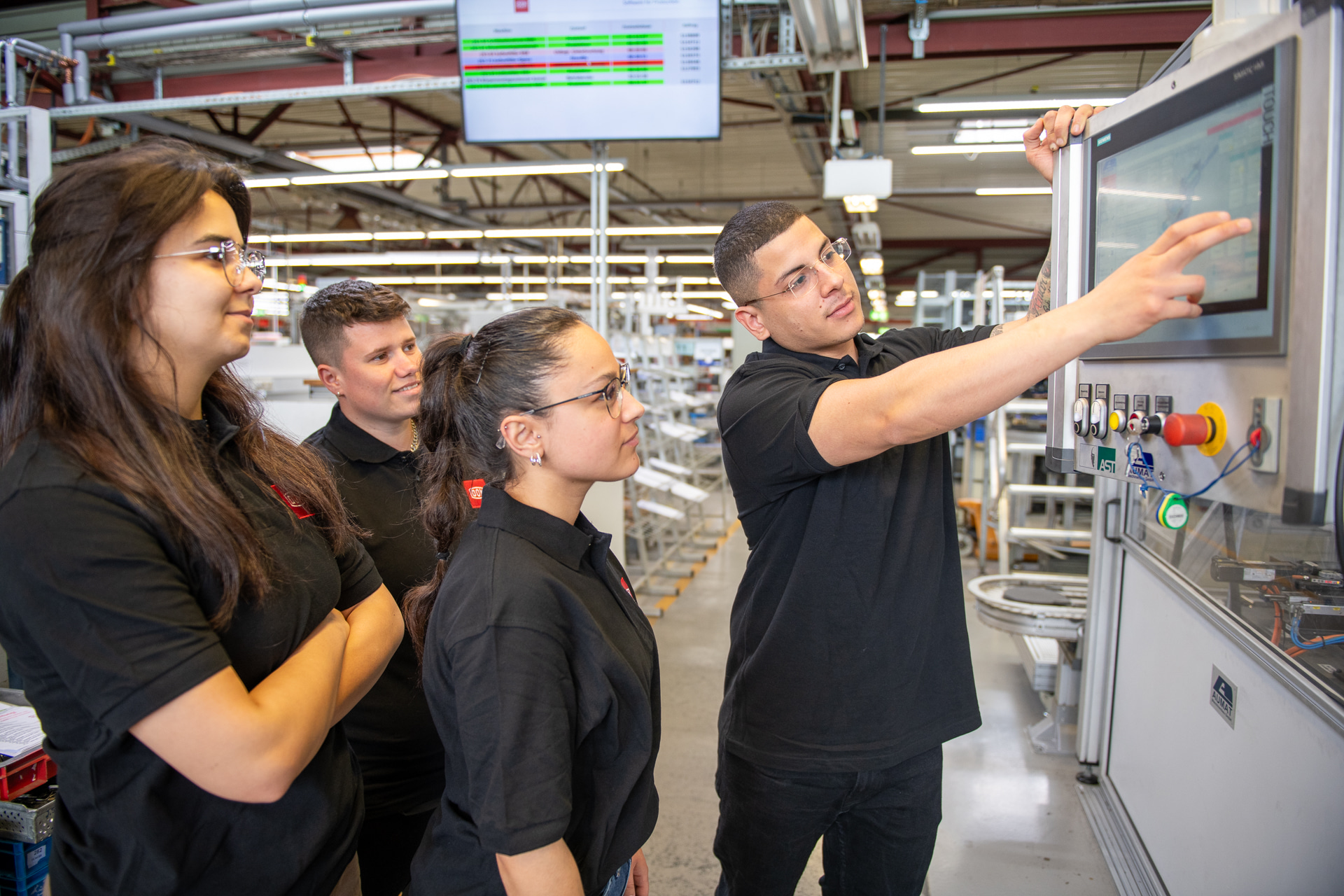 Auszubildende bei DOM Sicherheitstechnik lernen den Umgang mit modernen Produktionsanlagen.