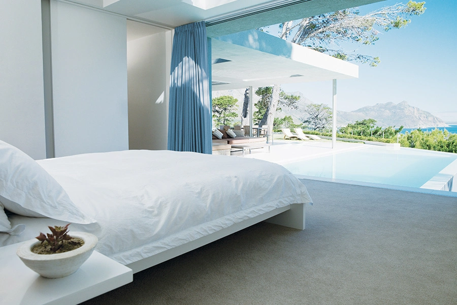 Schlafzimmer in einer Villa mit Blick auf den Infinity-Pool und das Meer