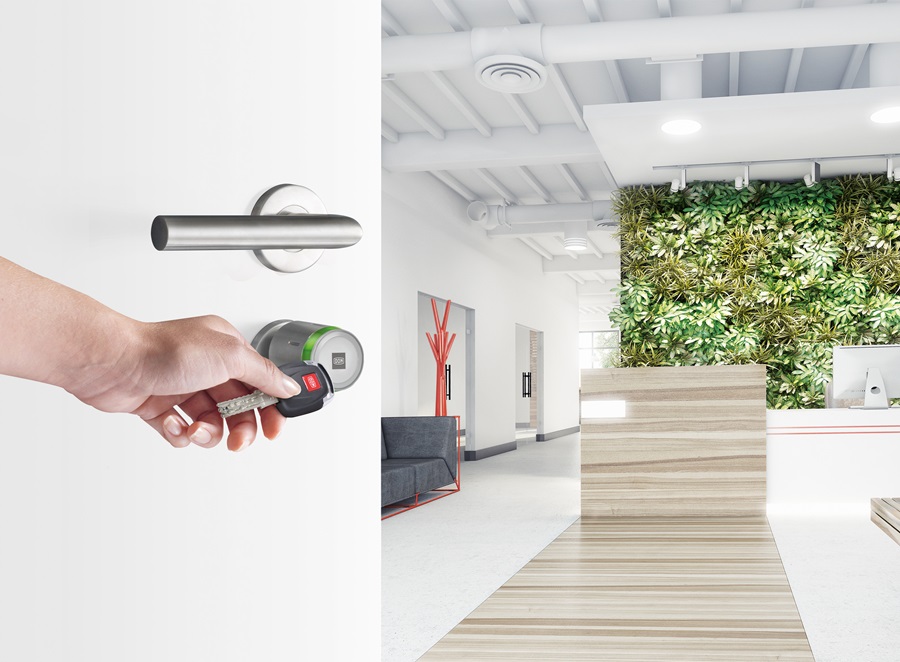 ENiQ Pro cylinder on a door is opened with a ClipTag, the lobby of an office can be seen in the background