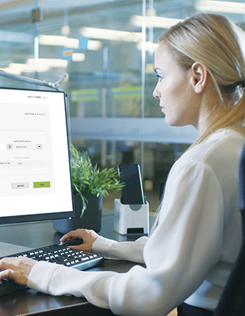 a woman sitting in front of the computer facing a software interface