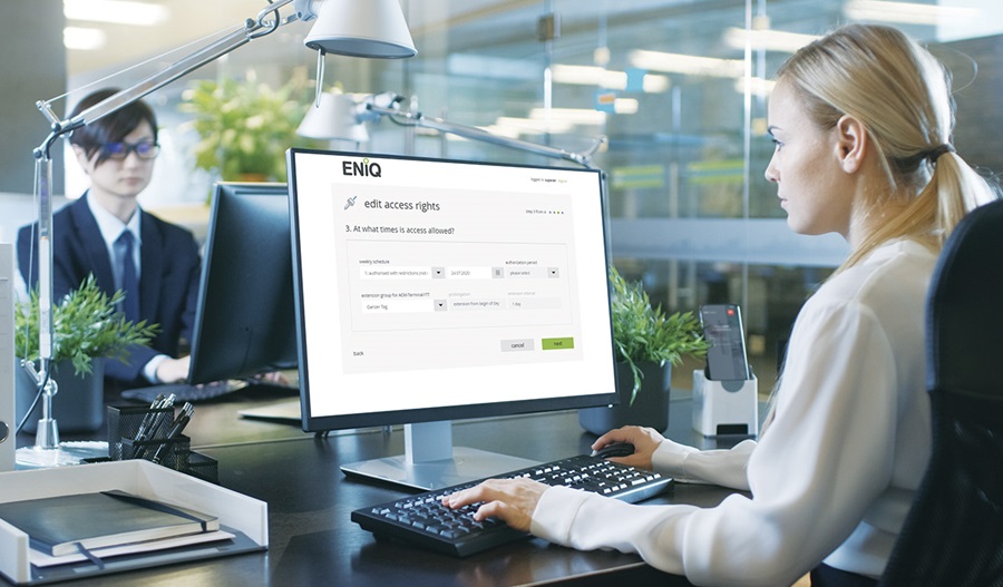 a woman in front of computer showing ENiQ software interface