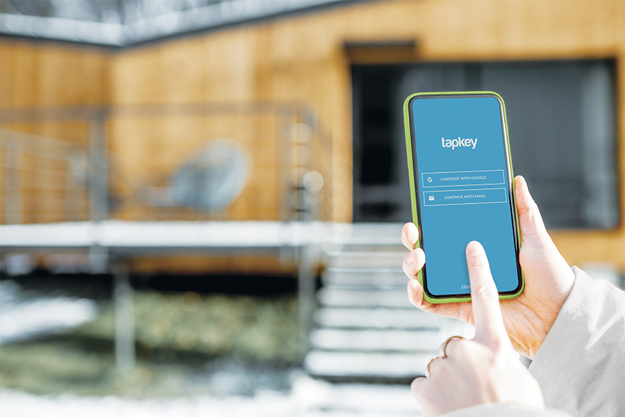 hand trying to open a holiday home door from the distance with a smartphone app