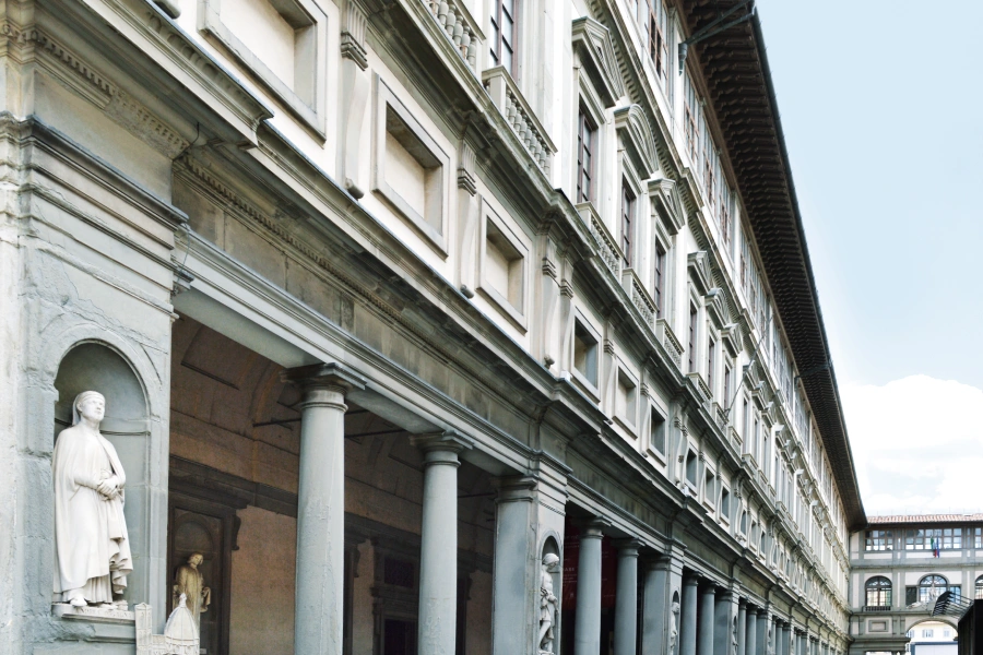 Exterior facade of the Uffizi Gallery in Florence with statues and columns.