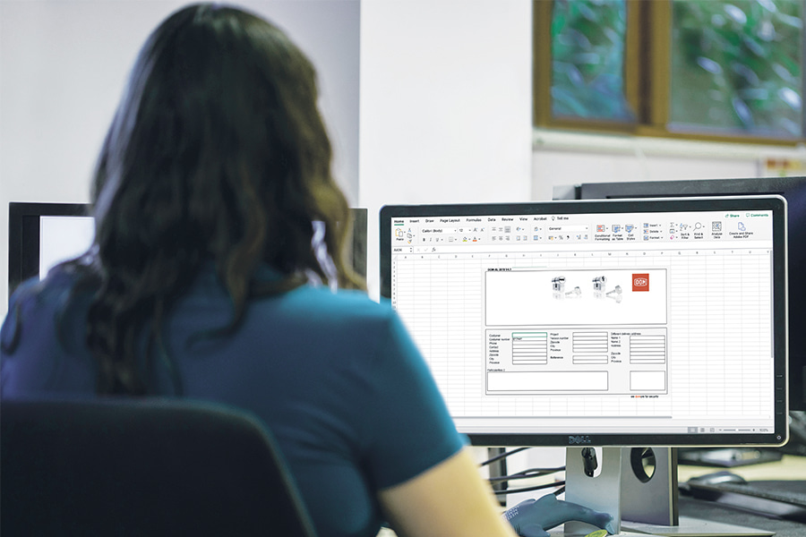 A woman sitting in front of a computer screen using the DOMXL software