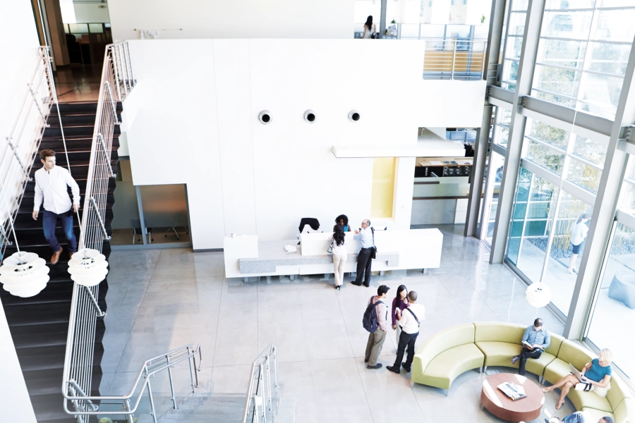 Interno moderno di un edificio con reception, scala e maniglioni antipanico sulle uscite.