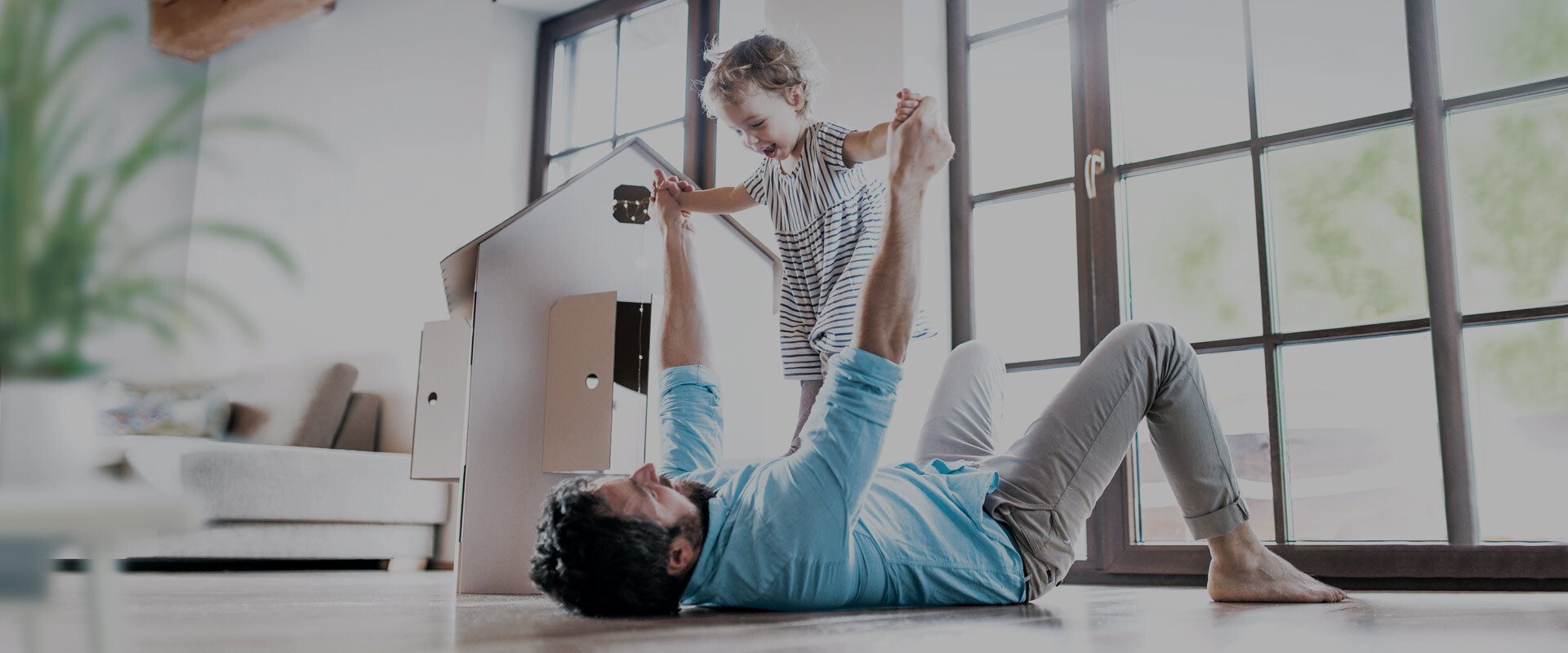 dad playing with daughter in the living room at home