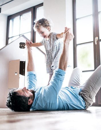 dad playing with daughter in the living room at home