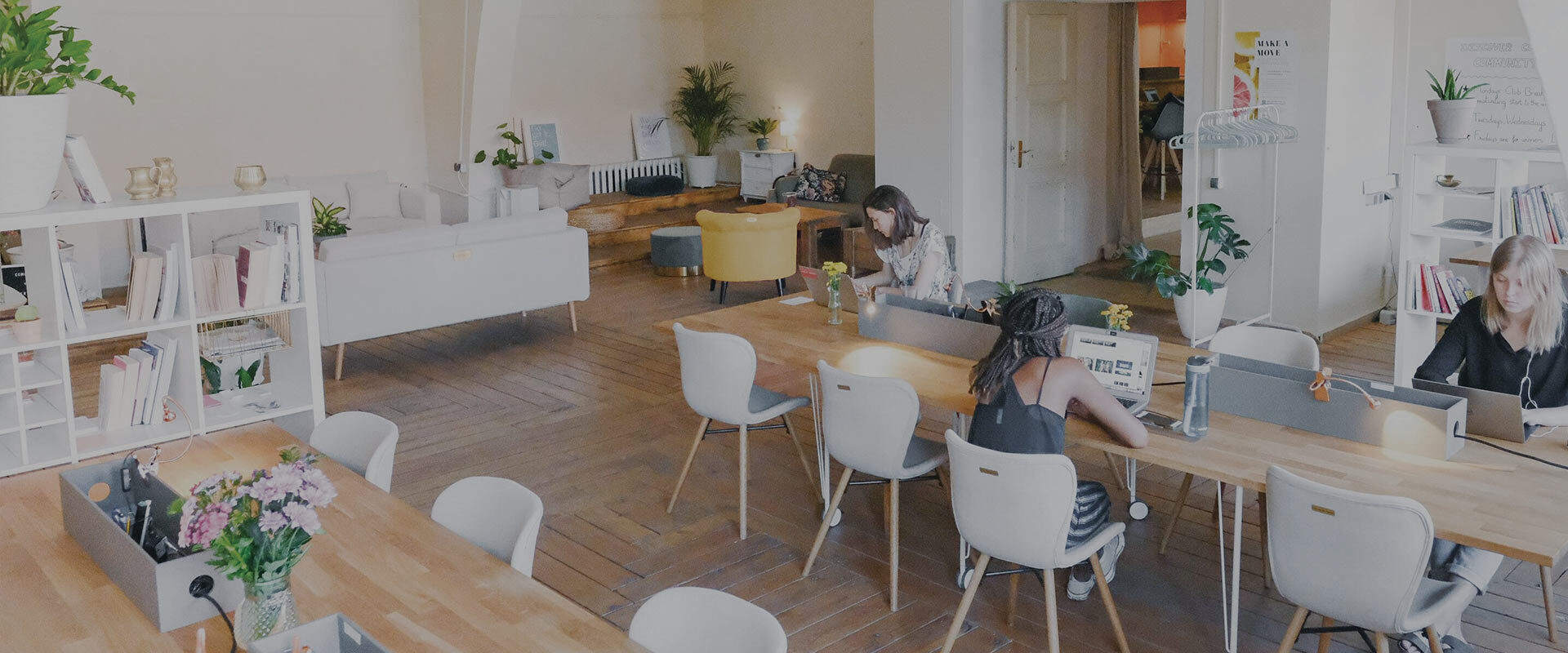 an empty coworking space with three women working apart