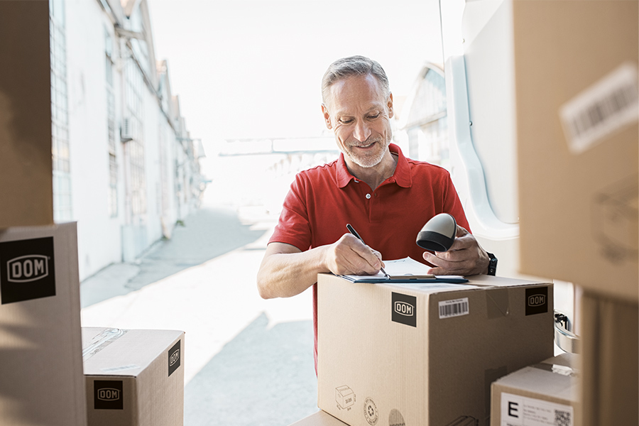a delivery man, going to deliver boxes of DOM products and checking the delivery note