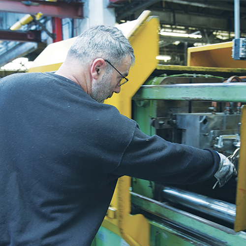 man working on a lock component manufacturing machine
