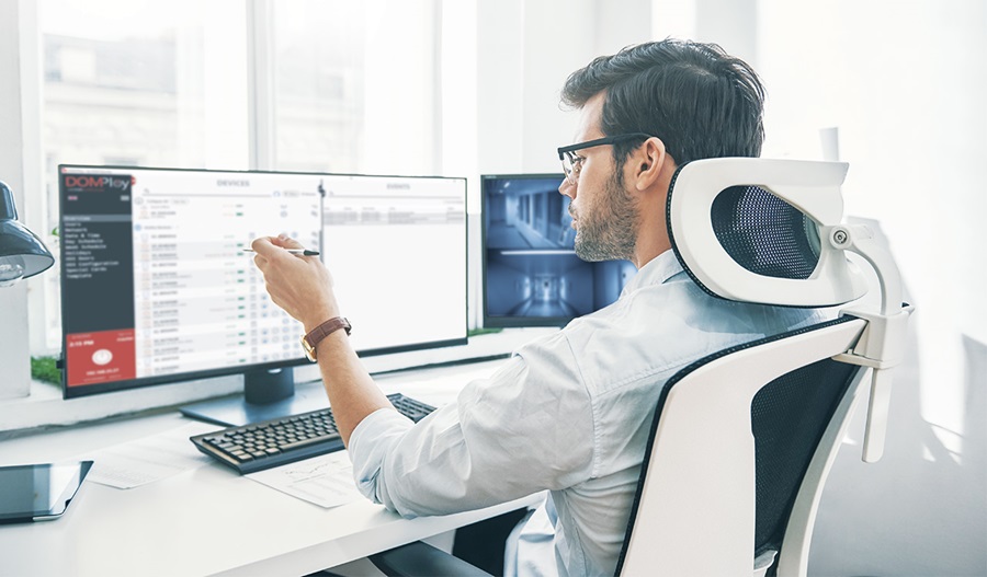 a person in front of computer screens looking at DOMPloy interface