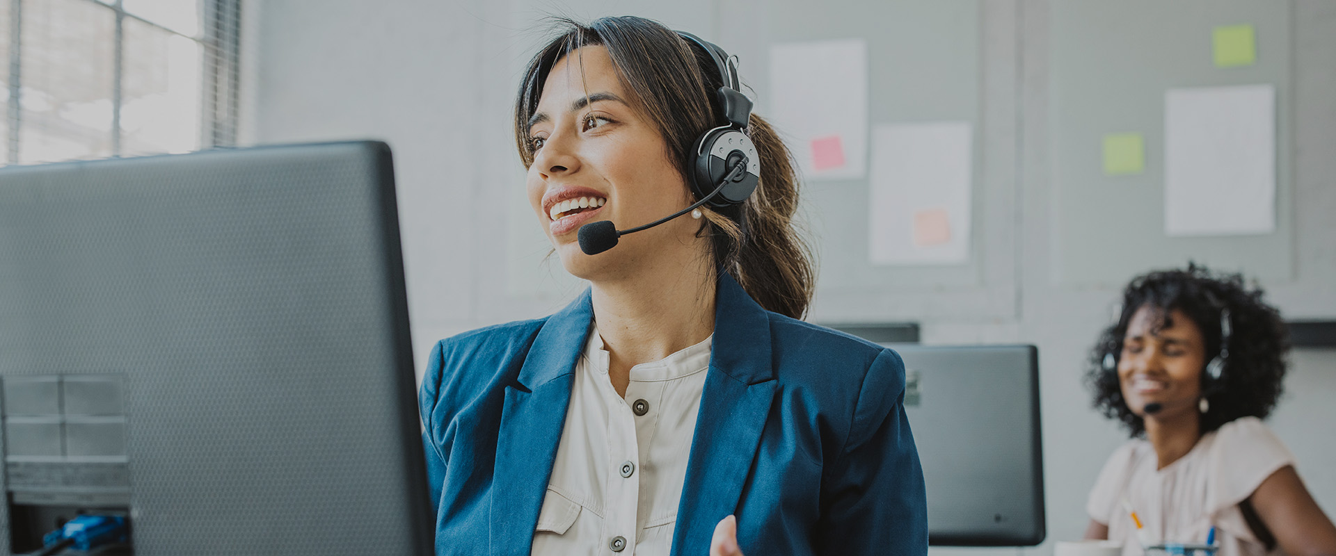 DOM Netherlands customer service representative wearing a headset, speaking with a client at her desk.
